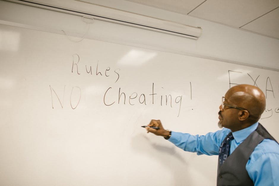 Teacher writes 'No Cheating!' on whiteboard during classroom instruction