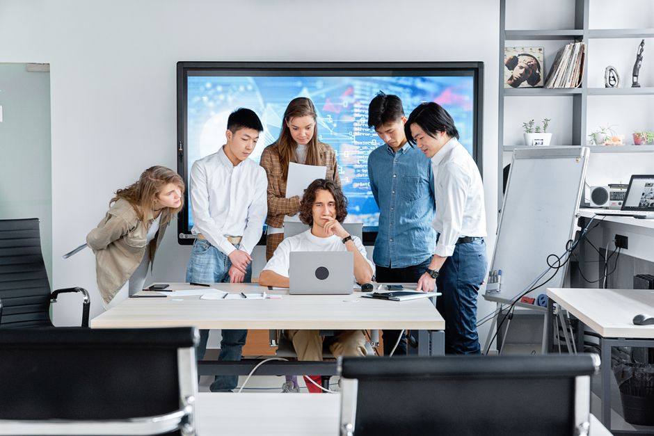 Diverse team collaborating on a software project in a contemporary office setting