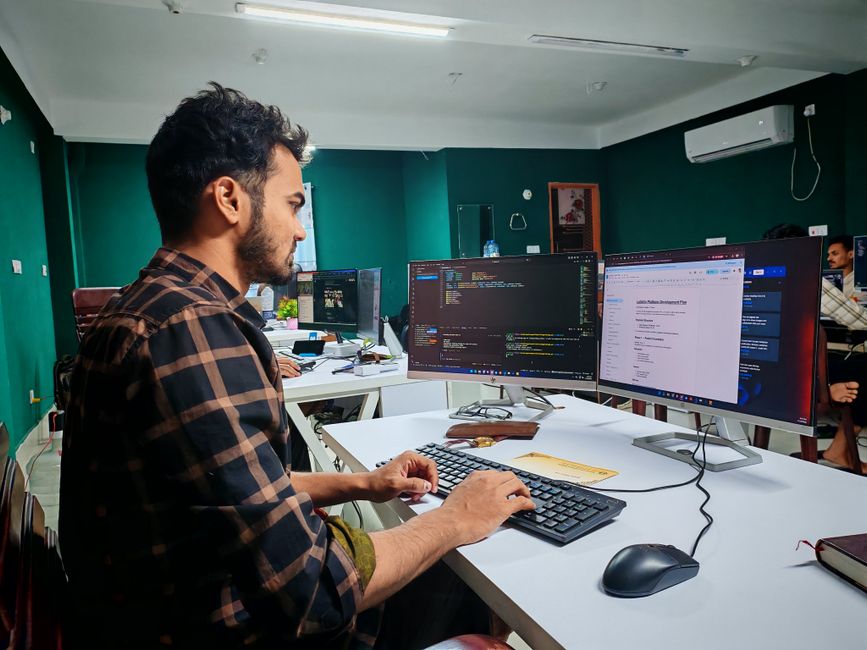 Softverski developer radi na dual monitor postavu u modernom uredu